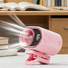 A pink clip-on mini electric fan is shown on a desk next to a stack of books.