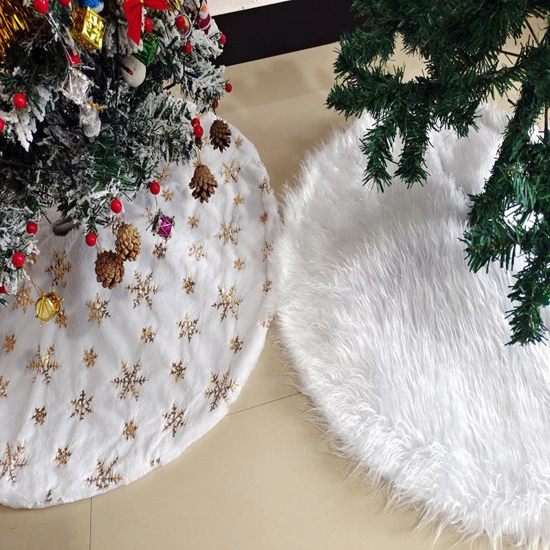White plush Christmas tree skirt decorated with gold snowflakes and surrounded by green pine branches