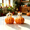 Two orange silicone candle molds shaped like cute ghosts resting on a white surface.