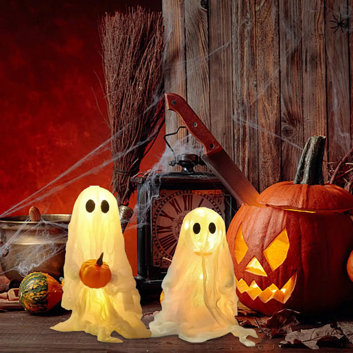 A set of lighted Halloween ghost decorations, including a glowing white ghost figure and an orange carved pumpkin.