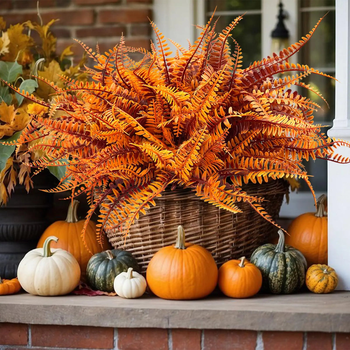 Dried orange and yellow foliage in a woven basket displayed on a brick ledge.