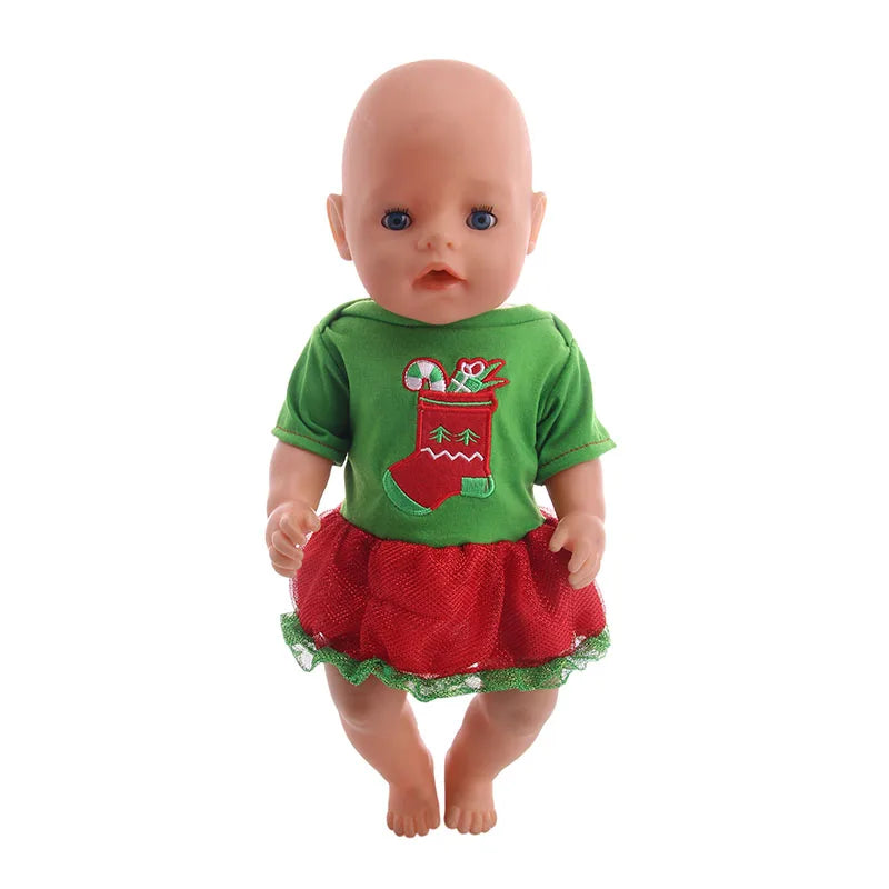 A baby doll wearing a green Christmas outfit with a red skirt and a festive decoration.