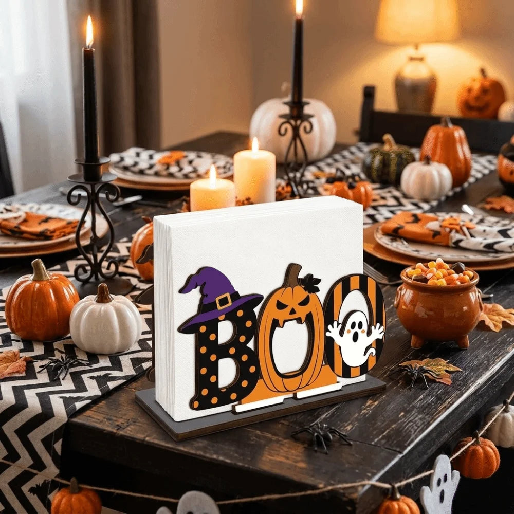 A wooden tissue dispenser shaped like a spooky Boo pumpkin with a witch hat design on a dark table.