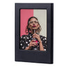 A black magnetic double-sided frame displaying a portrait of a woman with glasses holding a drink.