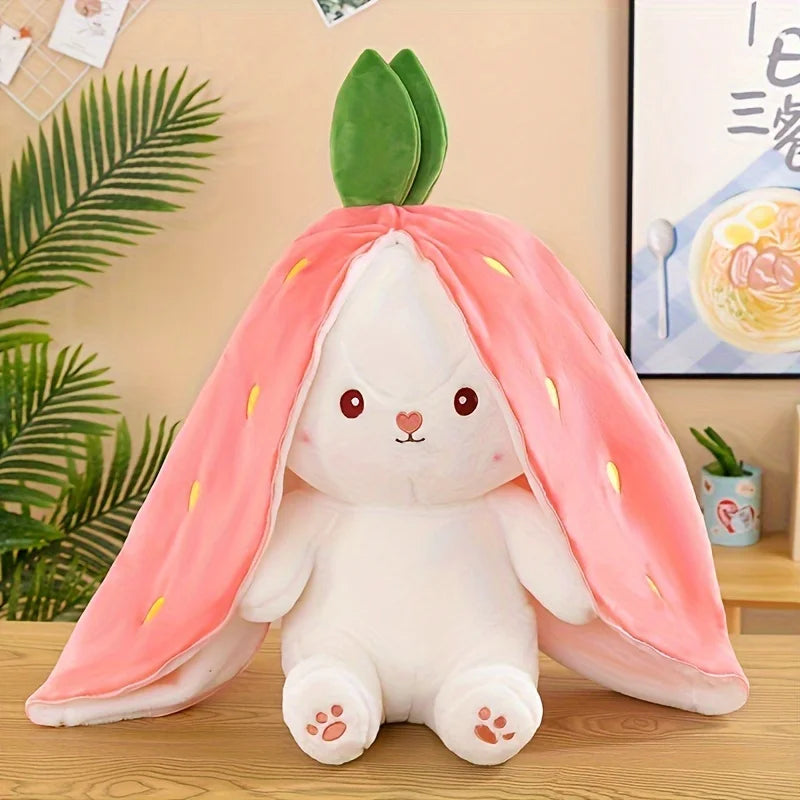 A white bunny plush toy with pink strawberry-like fabric draped over its head, set against a light background.