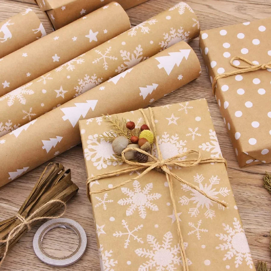 Rolls of festive snowflake Christmas wrapping paper and a finished gift wrapped in matching paper