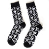 Pair of black novelty crew socks featuring a repeating pattern of white skulls, aliens, and tigers.