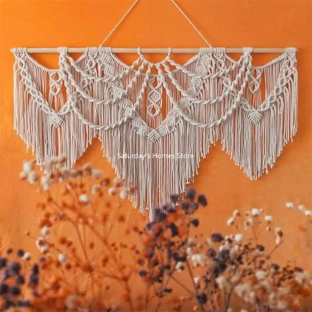 Handwoven boho macrame wall hanging tapestry in cream color against an orange background
