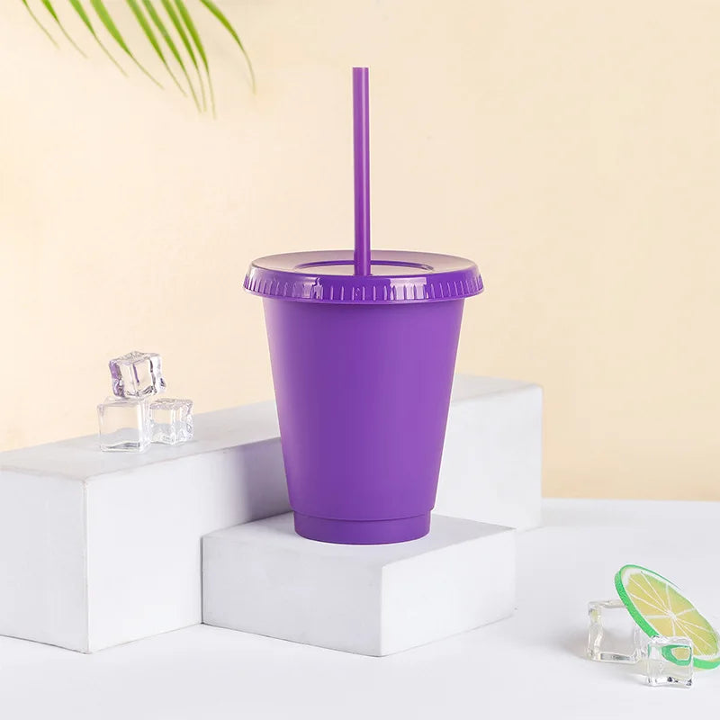 A purple BPA-free plastic cold cup with a lid and straw is displayed on a white surface.