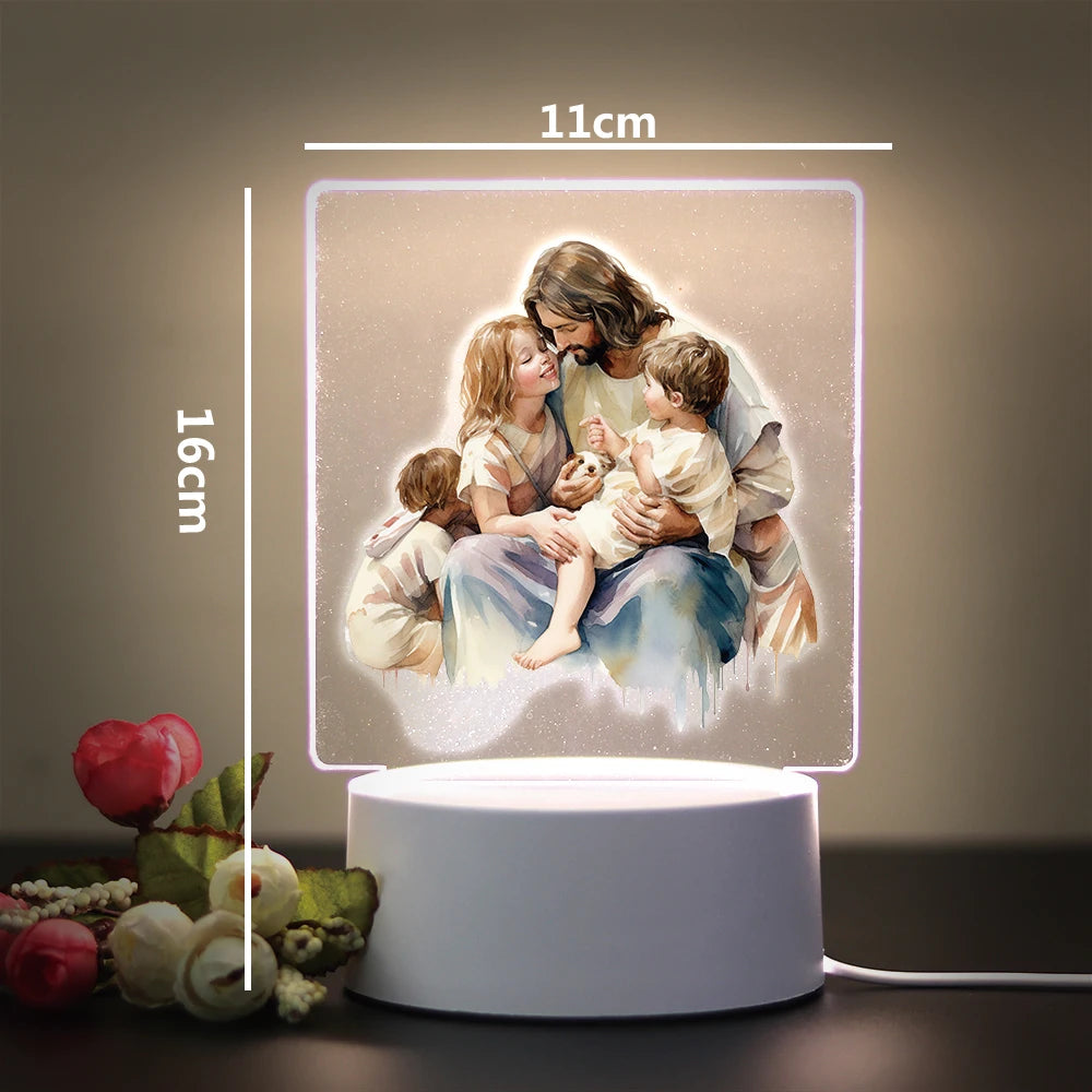 A 3D LED night light displays a painting of Jesus holding children, illuminated by a soft glow.