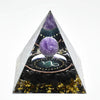 Handmade resin orgonite pyramid featuring natural obsidian and a copper coil.