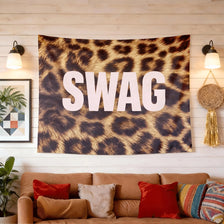 A dark brown leopard print tapestry wall hanging featuring the word SWAG in large white letters.