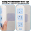 A close-up view of a white electrical outlet covered with a translucent adhesive tape for installation.