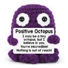 A purple crocheted octopus toy with a white message card that reads I may be a tiny octopus but I believe in you.