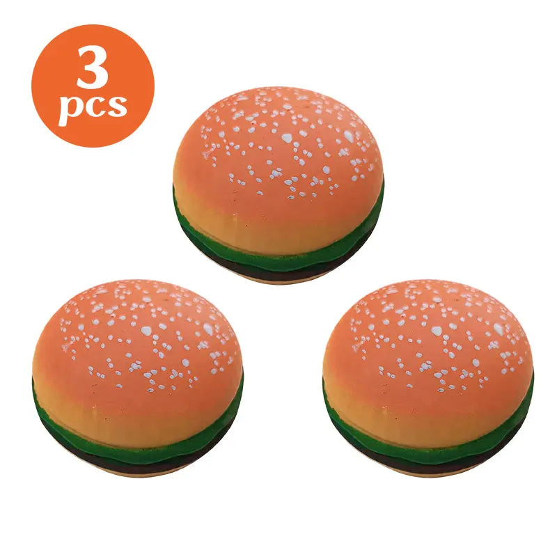 Three orange food-shaped stress balls resembling hamburger buns with white seeds.