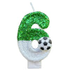 A custom number birthday candle shaped like the number 6, covered in green glitter and featuring a soccer ball design.