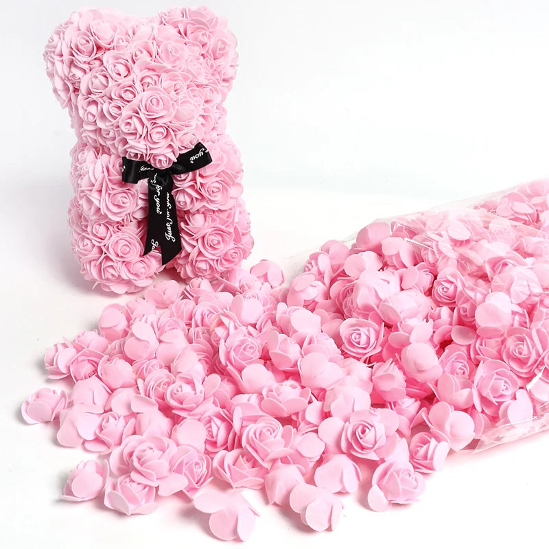 A pink foam rose bouquet with a black ribbon and a loose pile of pink rose petals.