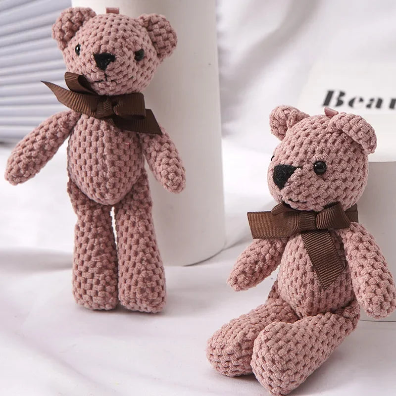 A handmade, soft pink teddy bear key pendant with brown ribbon details.