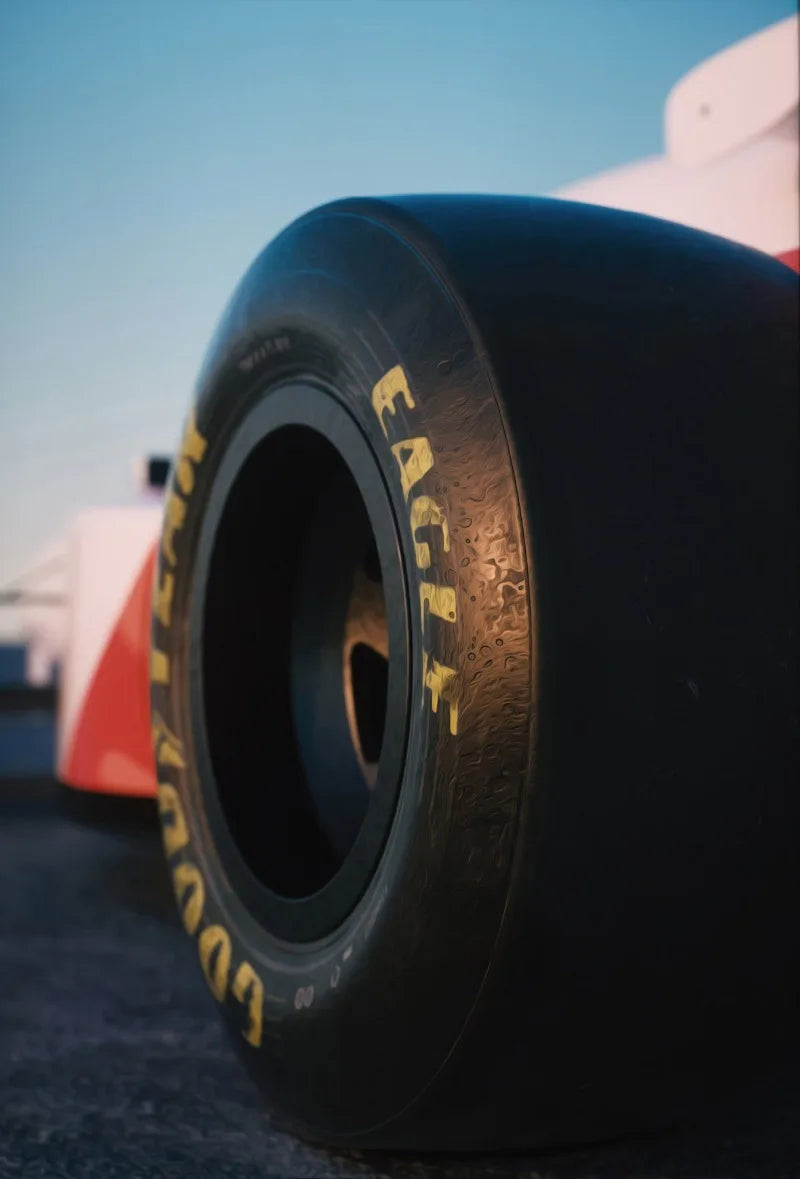 Close-up of a black racing tire with yellow lettering resting on a dark surface.