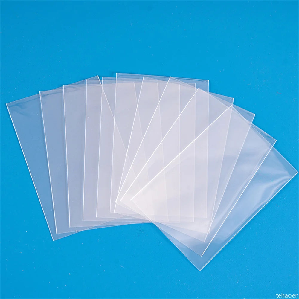 A stack of crystal clear protective card sleeves is displayed against a bright blue background.