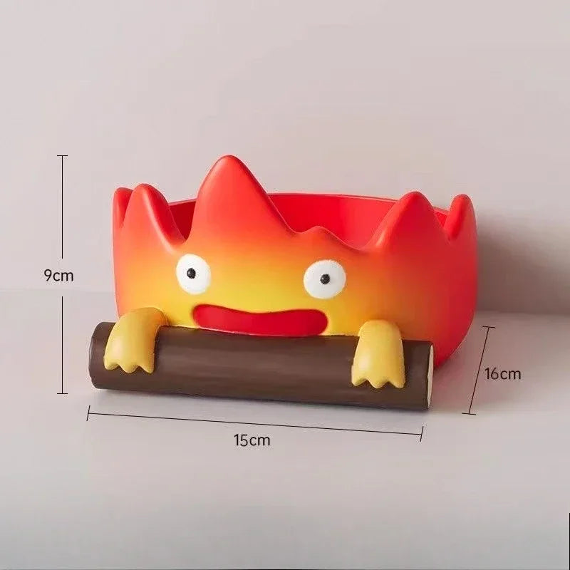 A resin cartoon fire person tray with an orange head and yellow arms resting on a brown base.