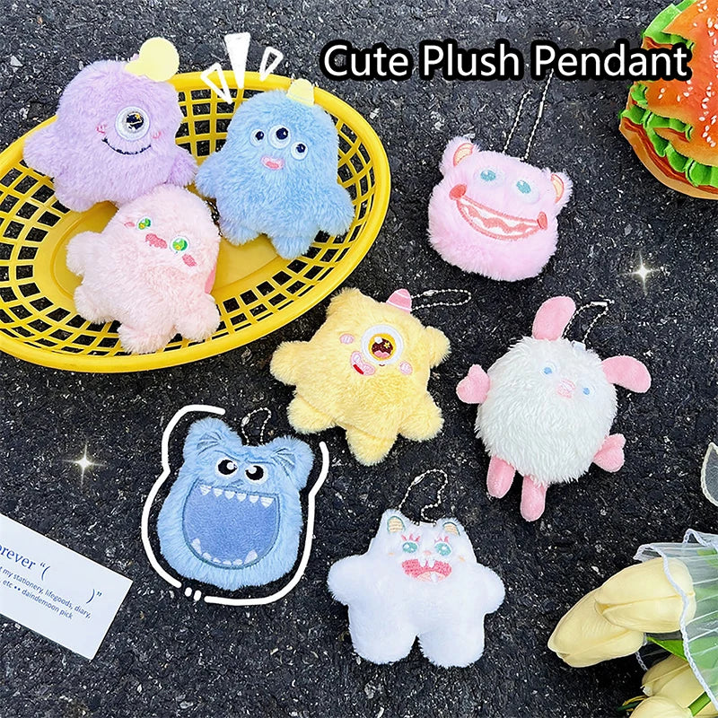 A collection of cute fuzzy plush monster pendants in various colors like purple blue pink and yellow against a dark backgroun