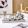Silver and gold foil resin letters spelling the word LOVE
