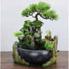 A resin desktop fountain featuring a mossy rock structure and a miniature green tree.