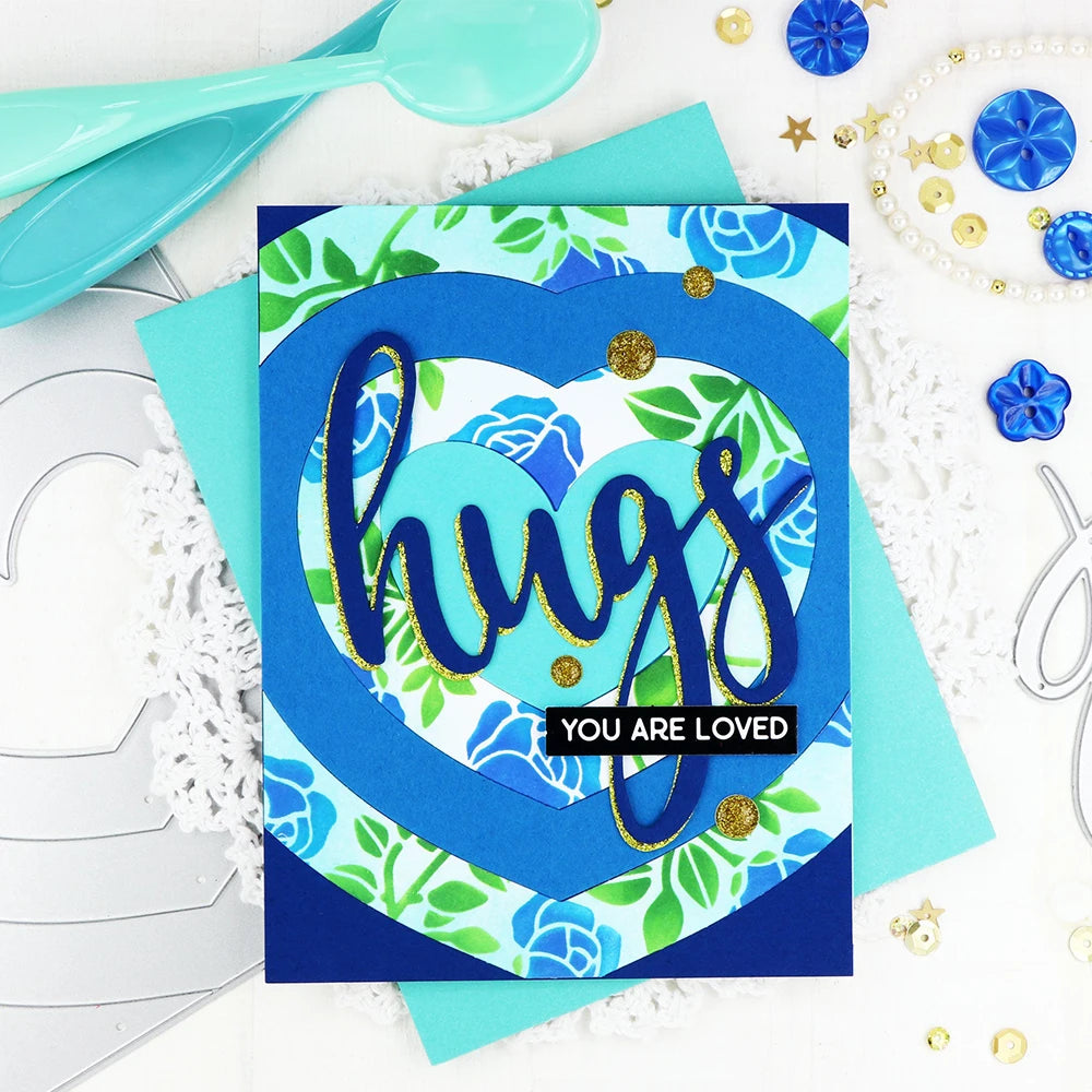 A blue heart shape with the word hugs written in gold script on a dark blue background surrounded by floral elements and gold