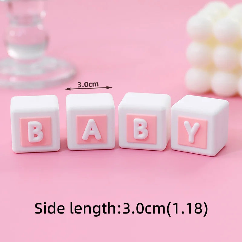 Set of three white cube cake toppers with pink letters B A B Y