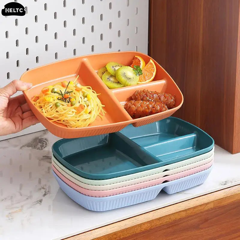 An orange 3-compartment portion control plate filled with pasta and meatballs, shown being held by a hand.