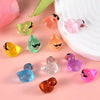 A collection of colorful glow-in-the-dark fruit turtle resin charms in various shades on a pink background.