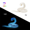 A white articulated snake fidget toy shown in both night and day lighting conditions.