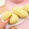 A yellow peanut-shaped stress ball is shown on a white tray next to a pink checkered napkin.