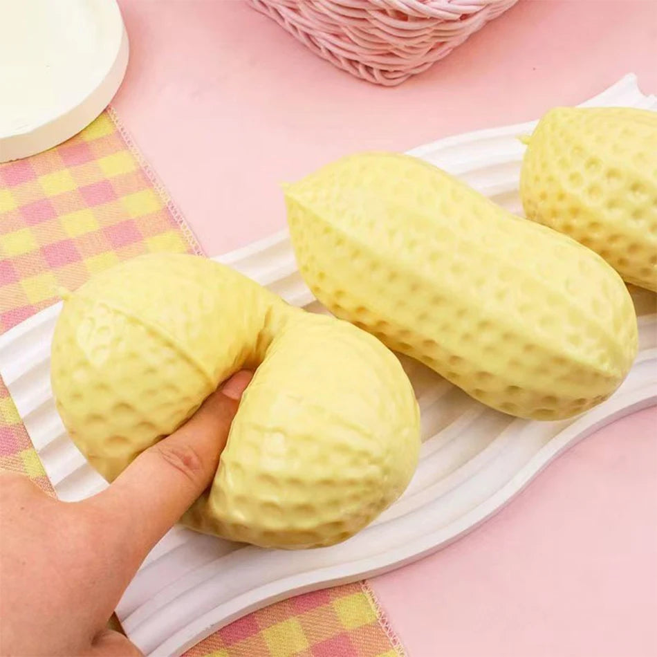A yellow peanut-shaped stress ball is shown resting on a white tray next to a pink checkered napkin.