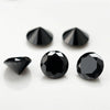 Three black round cut cubic zirconia stones of varying sizes displayed on a white surface.