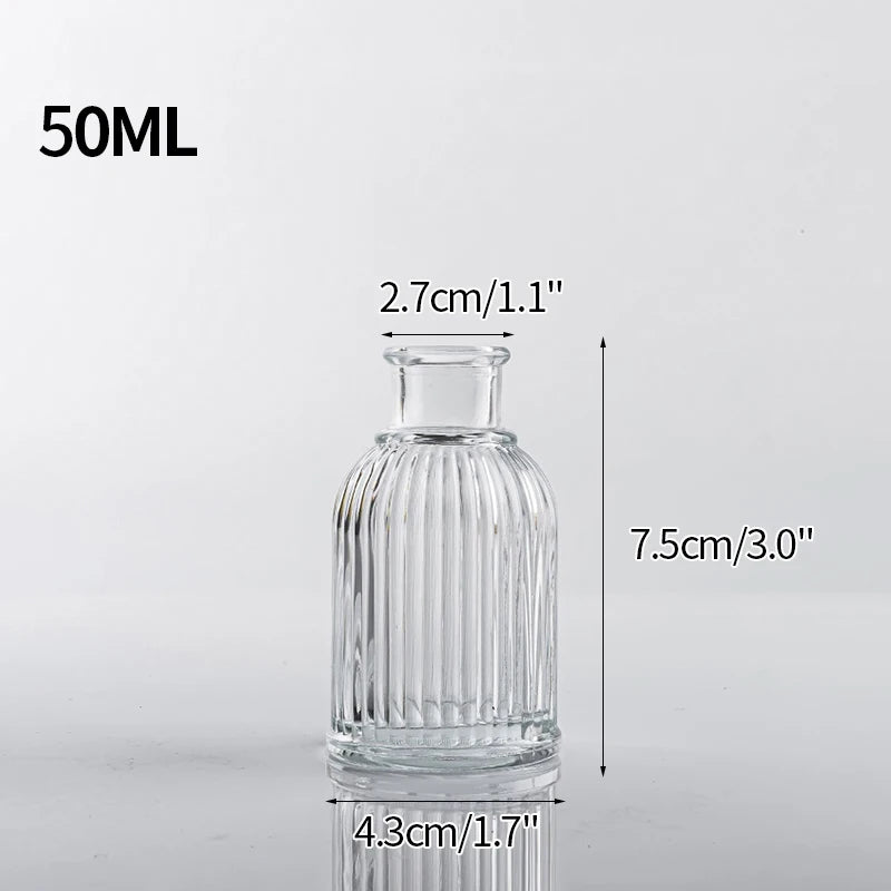 A clear glass bottle with a narrow neck and cylindrical body, measuring 7.5cm high and 4.3cm wide.