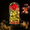 A glass vase filled with a red rose and glowing LED lights, set against a dark background.