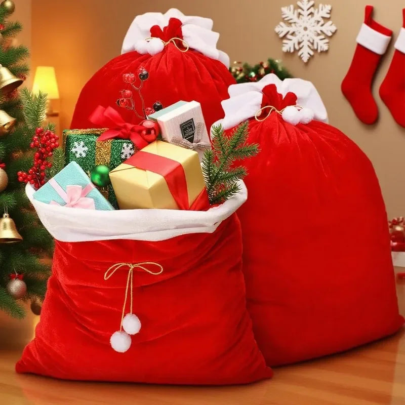 Red velvet Santa Claus gift bags filled with wrapped presents and festive greenery