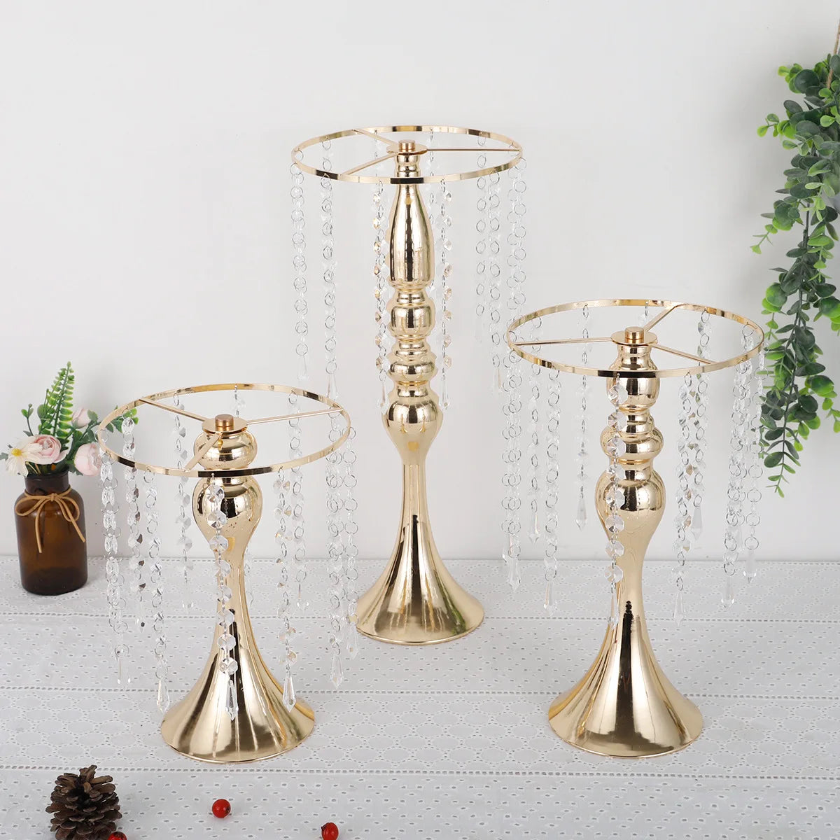 A set of gold crystal flower centerpiece stands with hanging clear crystals and candle holders.