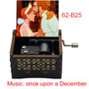 A hand-cranked wooden music box featuring an illustration of a couple, with the title Music: once upon a December.