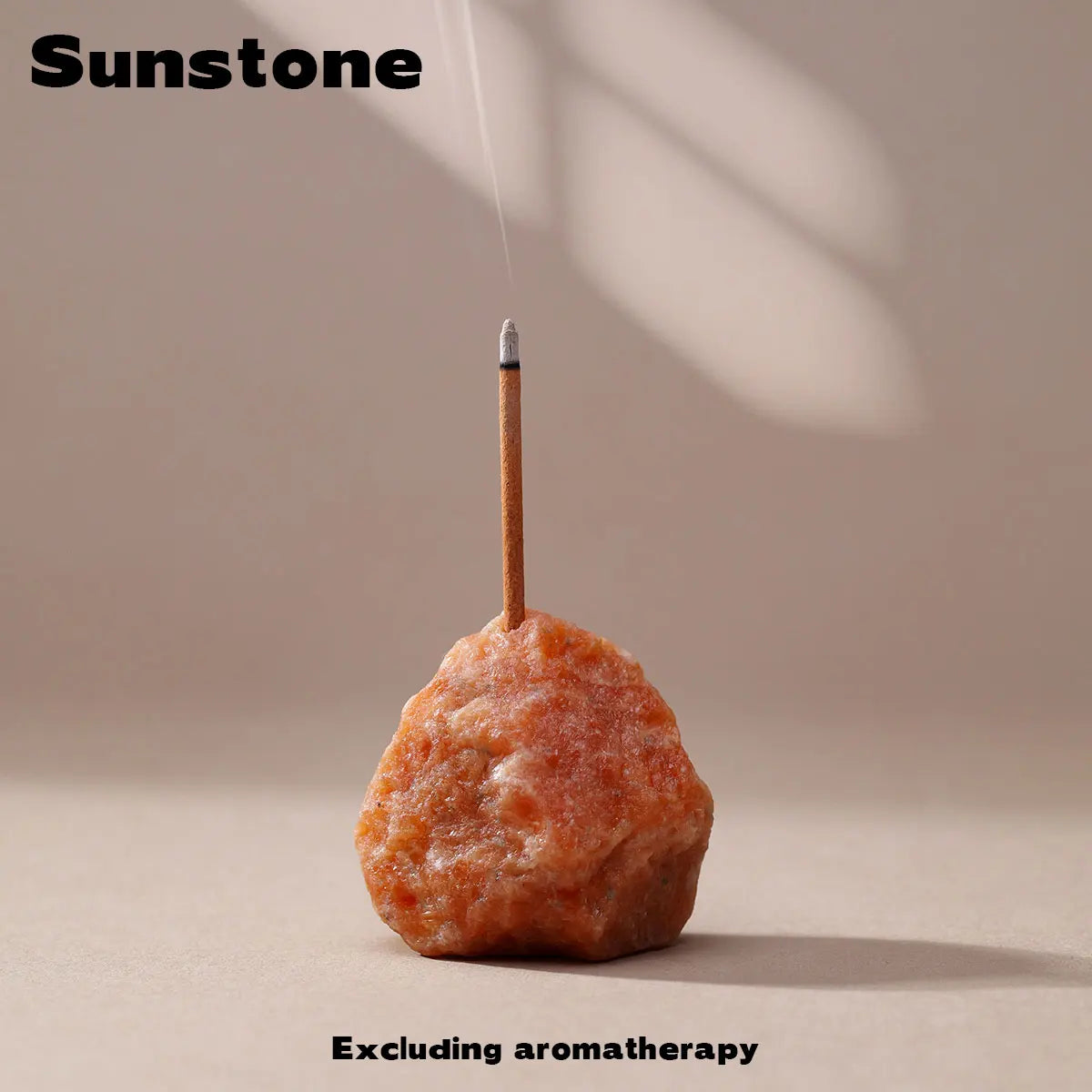 A piece of Sunstone mineral resting on a wooden stick, used as an aromatherapy holder.