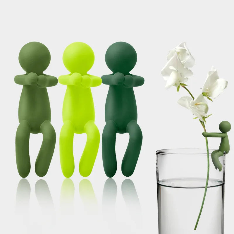 A set of three green and yellow human-shaped plant supports for hydroponic growth