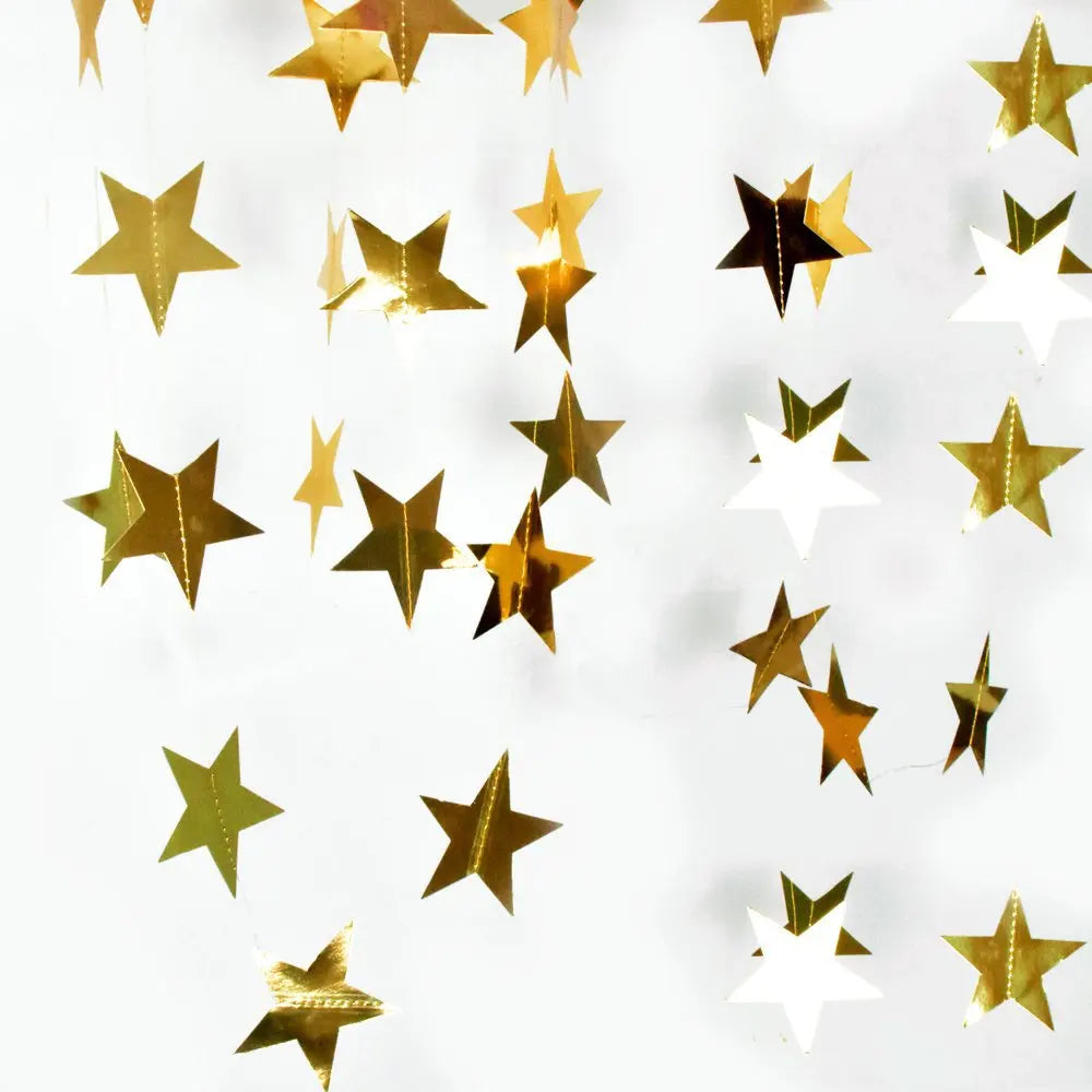 A string of shimmering gold and silver star paper bunting hanging against a white background.