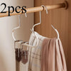 Two metal hat storage hooks hanging from a wooden rod against a light-colored wall.