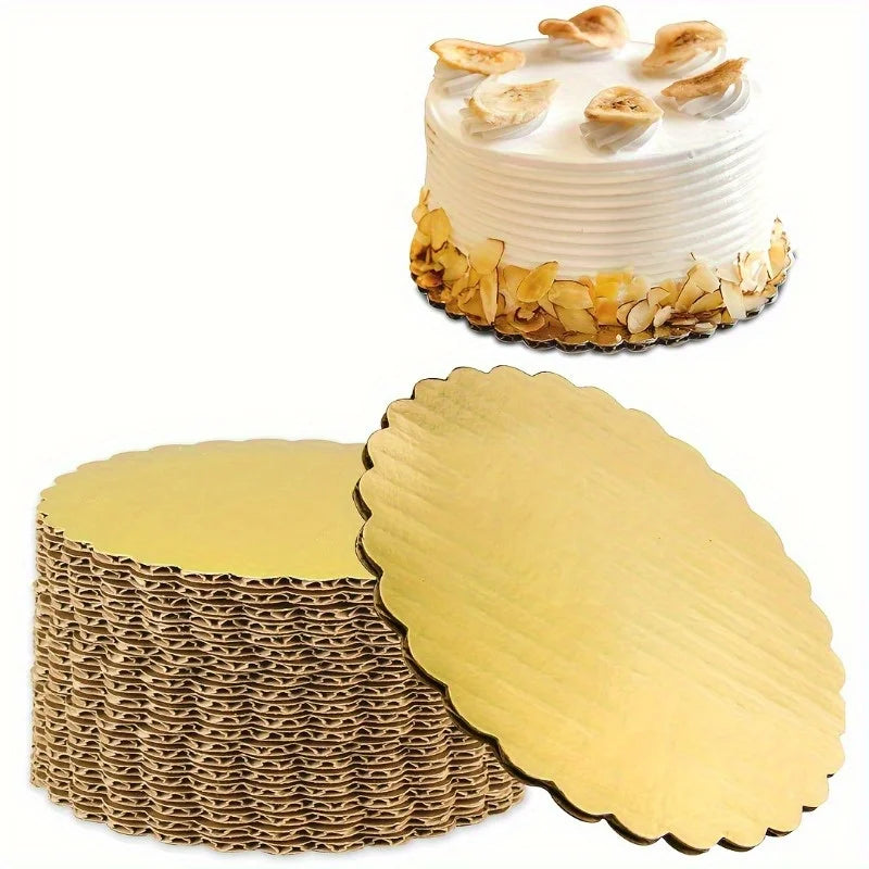 A white layer cake decorated with toasted coconut, next to a stack of gold disposable cake plates.