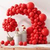 A vibrant red balloon arch display for weddings and parties, featuring numerous spherical balloons.