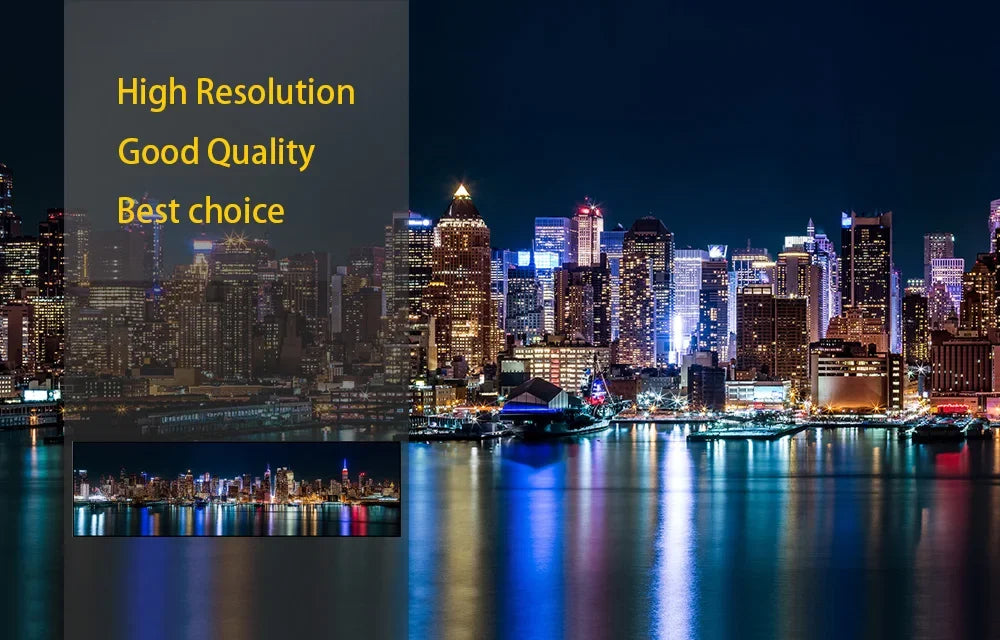 High resolution night view of the New York City skyline with illuminated buildings reflected on the water.