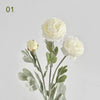A bouquet of white silk peony flowers with green leaves and stems.