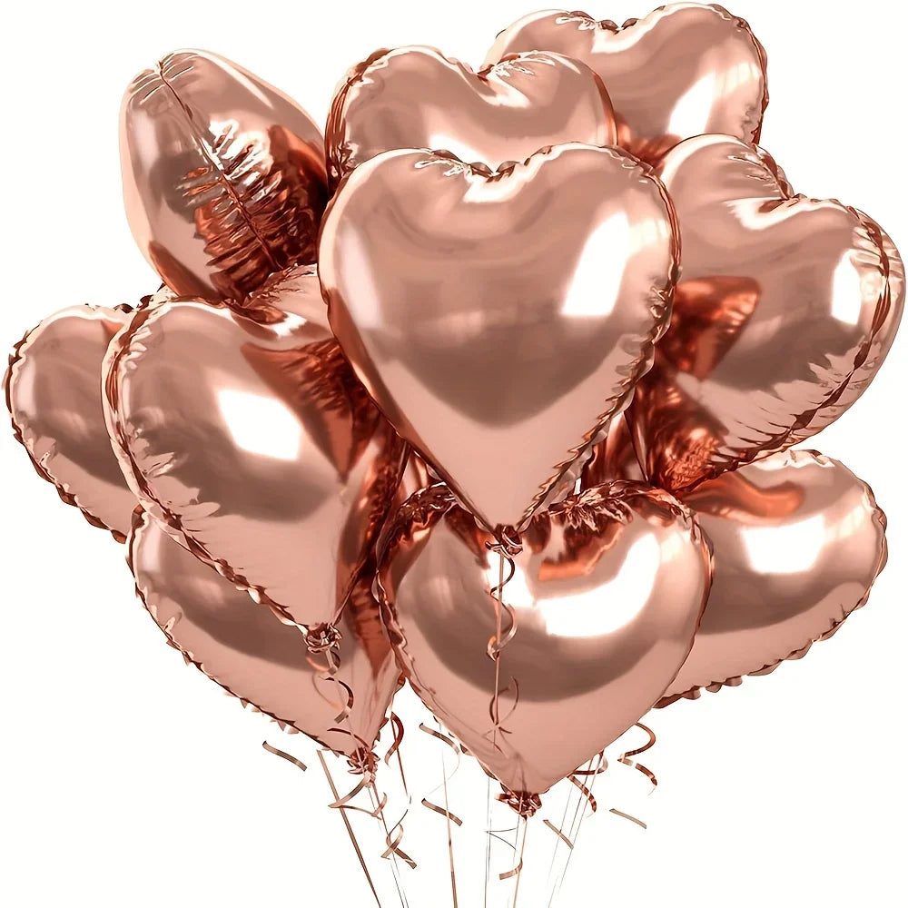 A cluster of ten rose gold heart-shaped foil balloons tied together for a celebration.